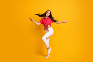 Fototapeta na wymiar Full length photo of sweet cute young lady wear red shirt dancing hands arms sides isolated yellow color background
