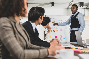 selective focus on African Americans are leading graph business meetings with people of diversity nationalities in office conference rooms. Concept Diversity meeting business room.