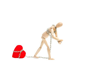 Maniqui de madera articulado con cadena tirando de un corazón rojo roto sobre un fondo blanco liso...