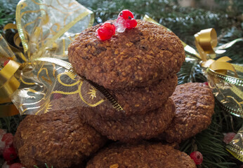 Christmas cookies with red currant berries yellow bows and ribbons on a background of green Christmas tree branches