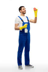 profession, cleaning service and people - happy smiling male worker or cleaner in overall and gloves with sponge and detergent over white background