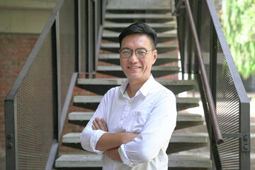 Portrait of a smiling Asian businessman wearing white shirt.