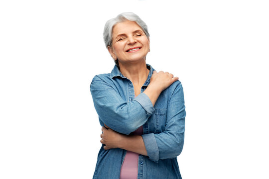 self-care, retirement and old people concept - portrait of smiling senior woman in denim shirt over white background