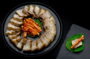 Bossam, boiled pork is eaten with spicy radish and Salted shrimp