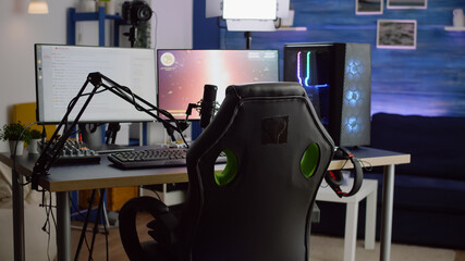Streaming professsional microphone in empty gaming home studio with neon lights. Game is over on...