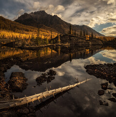Sunrise at lake in mountain range. Beautiful reflection of clouds in water - 430972702