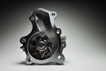 Close-up of an automobile engine liquid cooling pump. new part on gray gradient background