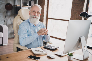 Photo of serious smiling employee dressed formal shirt working modern gadget indoors workplace workshop workstation