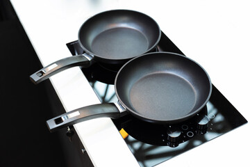 On the electric stove, two pans. Preparing to cook a fried dish. Close-up