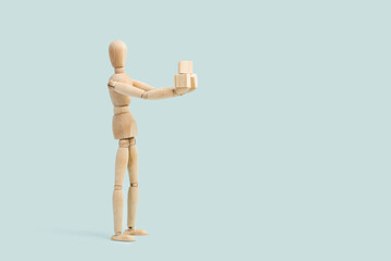 Maniqui sosteniendo cubos de madera sobre las manos sobre un fondo celeste liso y aislado. Vista de frente. Copy space. Concepto: Negocios