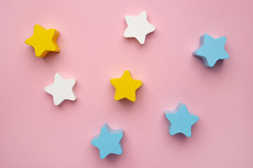 Children developmental toy for the development of motor skills, a crescent wooden stars balancer, on a pink background.