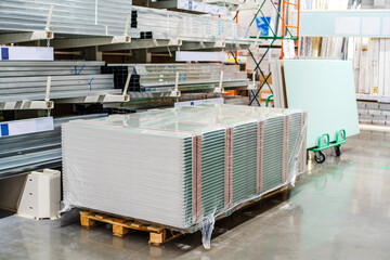 A stack of gypsum sheets lies in the trading floor of a building materials store