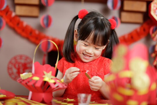 young chinese girl making traditional chinese "FU" means" lucky" lantern for celerating Chinese new year
