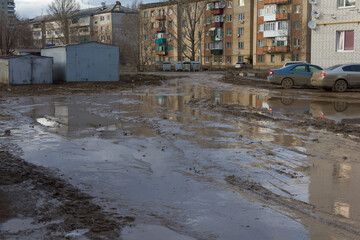 Fototapeta na wymiar Uralsk, Kazakhstan (Qazaqstan), 06.04.2016: mud on the street in the spring, mud in the spring on the road and city streets, poor city improvement, dirty street, mud after rain, dirty city