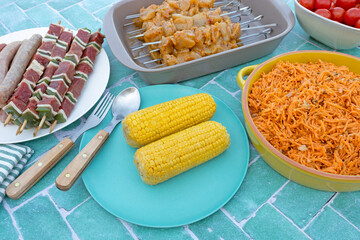table remplie de viandes pour le barbecue et de crudités	