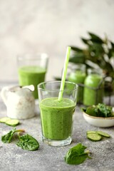 Healthy spinach, cucumber, kiwi, parsley smoothie with mineral water.