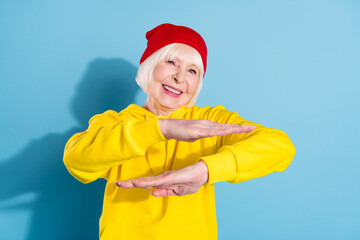 Photo of attractive old cool woman dance hip-hop wear red hat hoodie isolated on blue color background