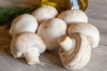 The fresh champignon mushrooms ready for cooking. A top view closeup of fresh mushrooms.