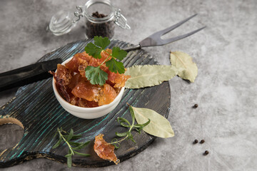 Dried meat on a round wooden cutting board with spices . Copy spase