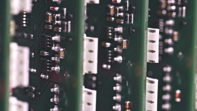 Slider shot video of electronic digital PCB boards on workshop table. Metal components and microcircuits lie on metal compartments during the production of cases of future powerful supercomputers