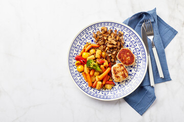 Plate with fried vegetables, carrots, broccoli, baby corn, bell peppers, roasted champignons and two chicken balls
