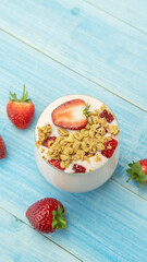 Strawberry yogurt on a blue wooden table.