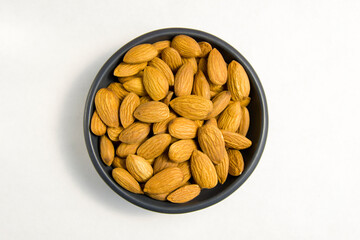 almonds in a black dish on a white background