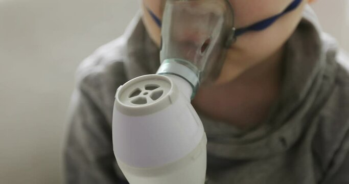 Close-up a sick child is doing inhalation. Asthma. Coronavirus.