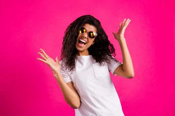 Portrait of attractive cool crazy cheerful girl wearing specs having fun isolated over vivid pink...