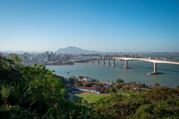 aerial view of a bridge over the sea with beach and tropical trees