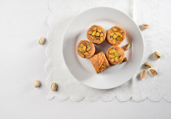 Top view of Pistachio filled Baklava rolls served on a modern white plate. Traditional Turkish...