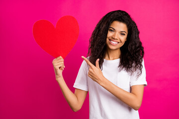 Photo of lovely brunette young lady point heart wear white t-shirt isolated on pink color background