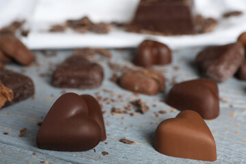 Beautiful heart shaped chocolate candies on wooden table, closeup
