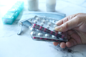 Close up of senior man hand holding blister packs .