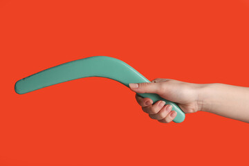 Woman holding boomerang on red background, closeup