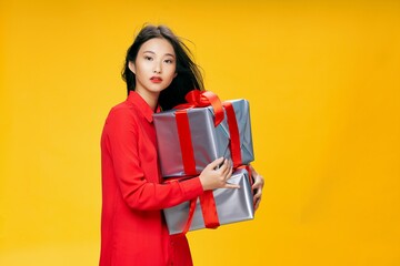 woman of asian appearance holding a gift gift birthday celebration yellow background