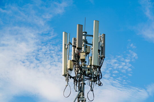 Telecommunication tower of 4G and 5G cellular. Macro Base Station. 5G radio network telecommunication equipment with radio modules and smart antennas mounted on a metal on cloulds sky background.