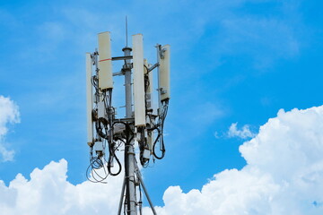 Telecommunication tower of 4G and 5G cellular. Macro Base Station. 5G radio network telecommunication equipment with radio modules and smart antennas mounted on a metal on cloulds sky background.