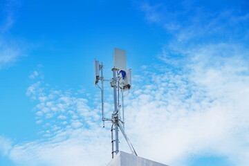 Telecommunication tower of 4G and 5G cellular. Macro Base Station. 5G radio network telecommunication equipment with radio modules and smart antennas mounted on a metal on cloulds sky background.