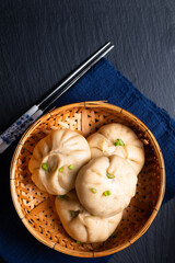 Food concept spot focus homemade organic dim sum Baozi, or bao pork Chinese Steamed Buns on black...