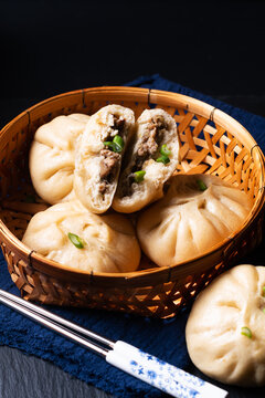 Food concept spot focus homemade organic dim sum Baozi, or bao pork Chinese Steamed Buns on black background with copy space