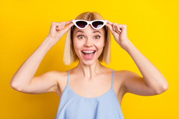 Photo of cheerful nice blond short hair lady wear spectacles blue top isolated on yellow color...