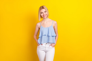 Fototapeta na wymiar Photo of cheerful nice blond short hair lady stand wear blue top isolated on vivid yellow color background