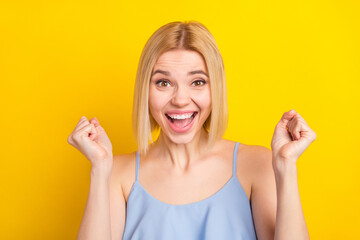 Obraz premium Photo of hooray cute blond short hair lady hands fists wear blue top isolated on vivid yellow color background
