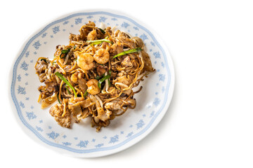 Overhead view of Penang char kuey teow is popular fried noodle with coceral, shrimp and eggs in black sauce in Malaysia