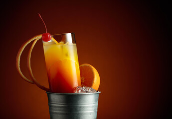 Cocktail tequila sunrise in a metal bucket with ice.