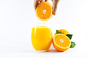 Glass of fresh orange juice with fruits cut in half and sliced with green leaf isolated on white background, clipping path