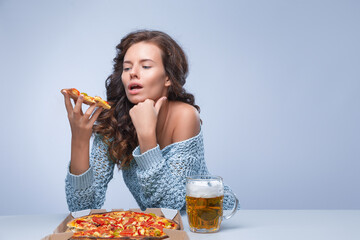 Happy woman with pizza and beer on grey background, space for text