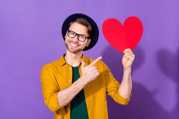 Photo of young man happy positive smile point finger paper card heart adverise advice suggest...