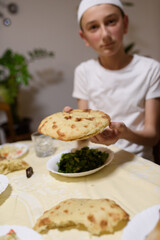 A Muslim boy eats various foods during iftar.